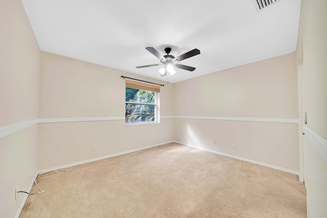 carpeted spare room featuring ceiling fan and a textured ceiling