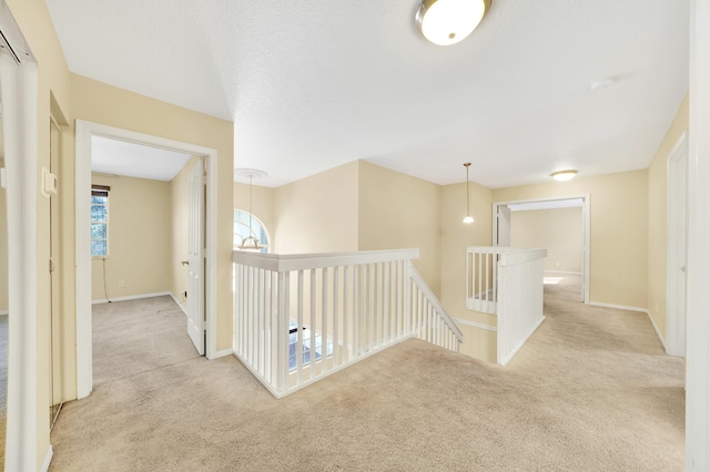 hall with light colored carpet