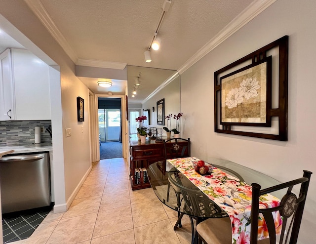 hall featuring crown molding, track lighting, a textured ceiling, and light tile patterned flooring