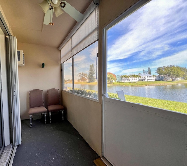 unfurnished sunroom with ceiling fan and a water view