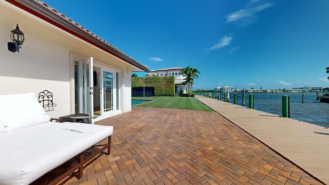 view of patio / terrace with a dock, a water view, and french doors