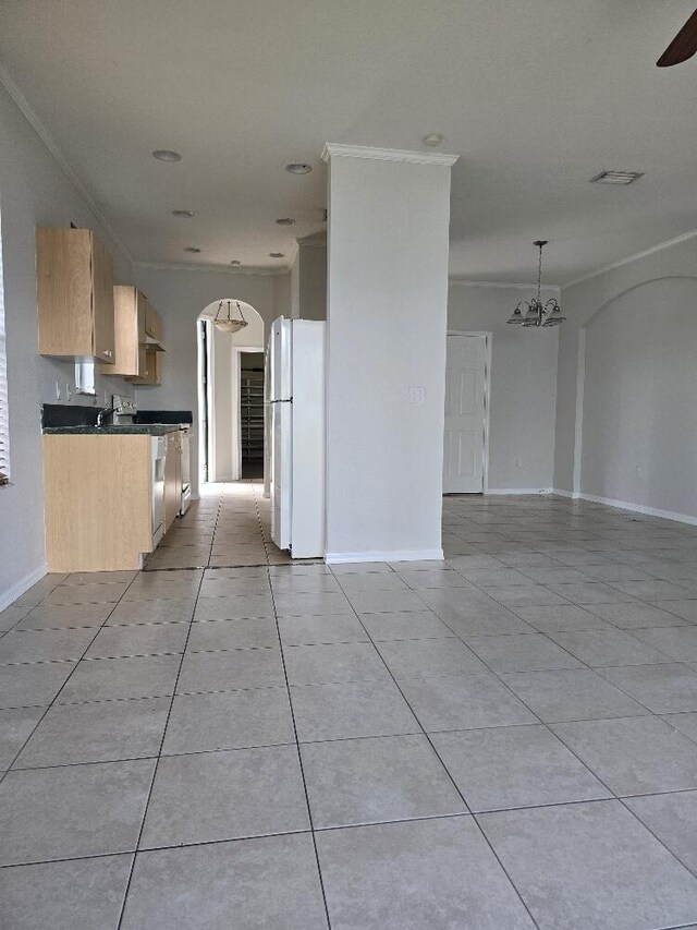 kitchen with sink, light brown cabinets, white appliances, light tile patterned floors, and ornamental molding