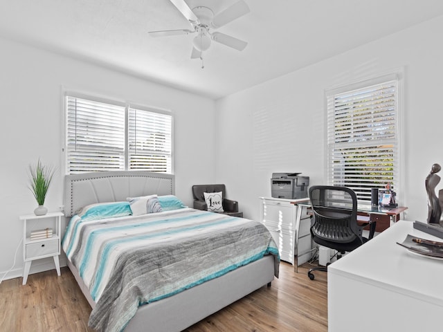 bedroom with ceiling fan, light wood-type flooring, and multiple windows