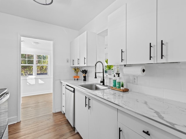 kitchen with white cabinetry, sink, dishwasher, light stone counters, and light wood-type flooring