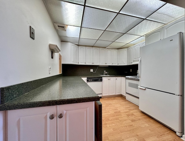 kitchen featuring a drop ceiling, light hardwood / wood-style flooring, white appliances, decorative backsplash, and white cabinets