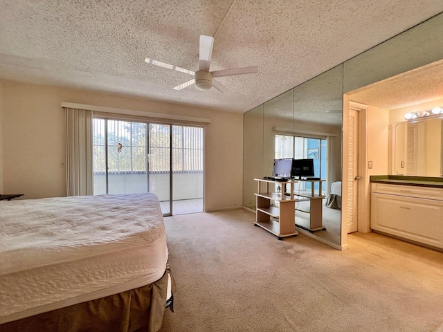 bedroom featuring connected bathroom, access to exterior, ceiling fan, light colored carpet, and a textured ceiling