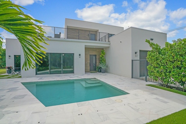 rear view of property featuring a patio and a balcony