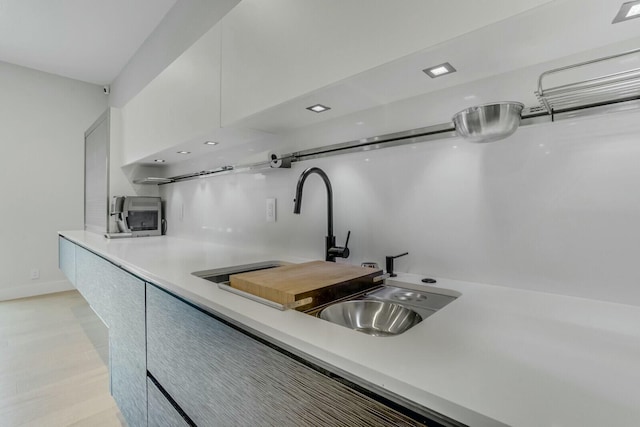 kitchen featuring white cabinetry and sink