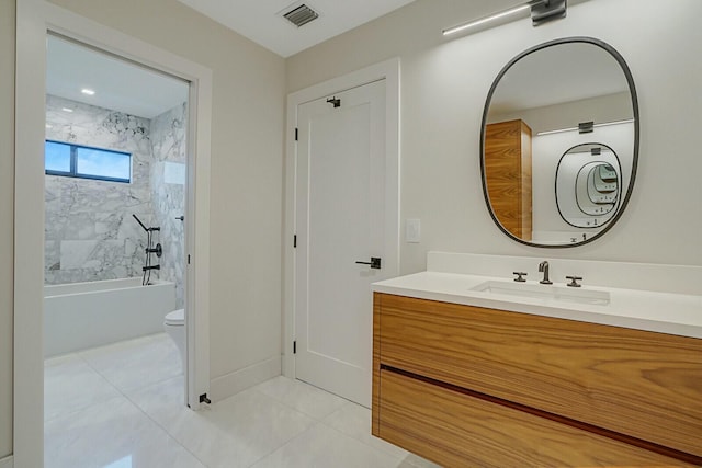 full bathroom featuring vanity, tiled shower / bath combo, toilet, and tile patterned flooring