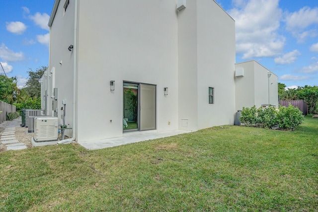 back of house with a lawn and central AC unit