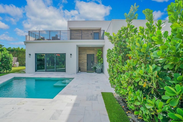 rear view of property featuring a patio area and a balcony