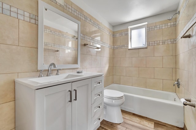 full bathroom featuring toilet, vanity, tile walls, and hardwood / wood-style flooring