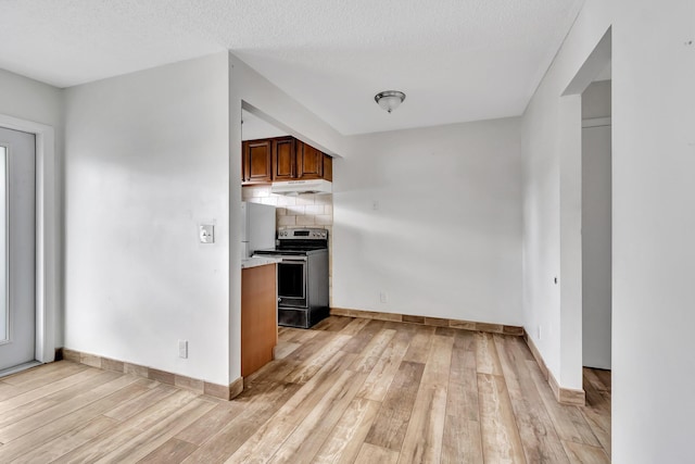 kitchen with a textured ceiling, tasteful backsplash, light hardwood / wood-style flooring, and range with electric stovetop