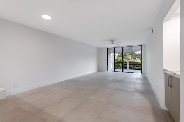 unfurnished room with ceiling fan and floor to ceiling windows