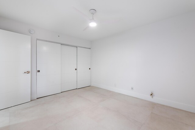 unfurnished bedroom featuring ceiling fan and a closet