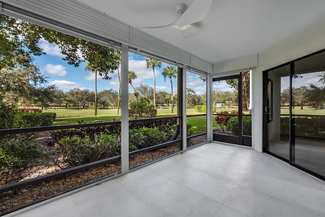 unfurnished sunroom with ceiling fan