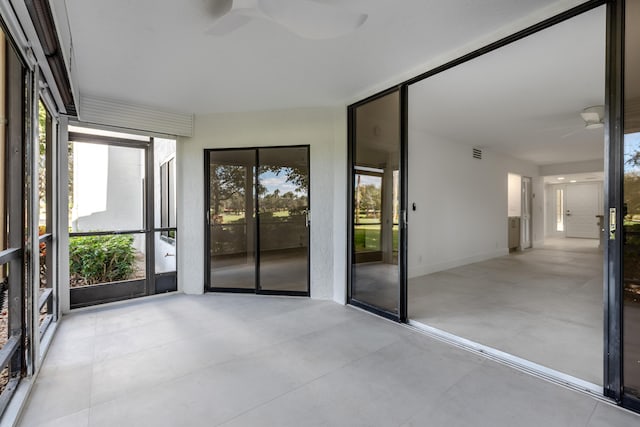 unfurnished sunroom with ceiling fan and a healthy amount of sunlight