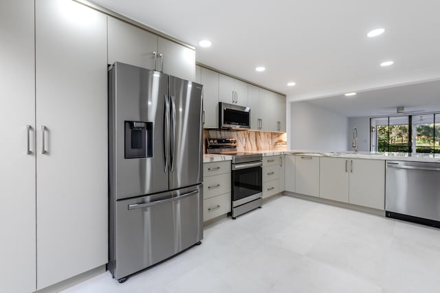 kitchen with decorative backsplash, appliances with stainless steel finishes, ceiling fan, and sink