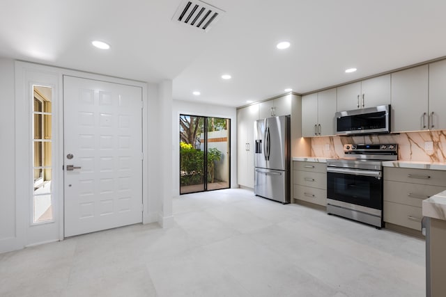 kitchen with backsplash, gray cabinets, and stainless steel appliances