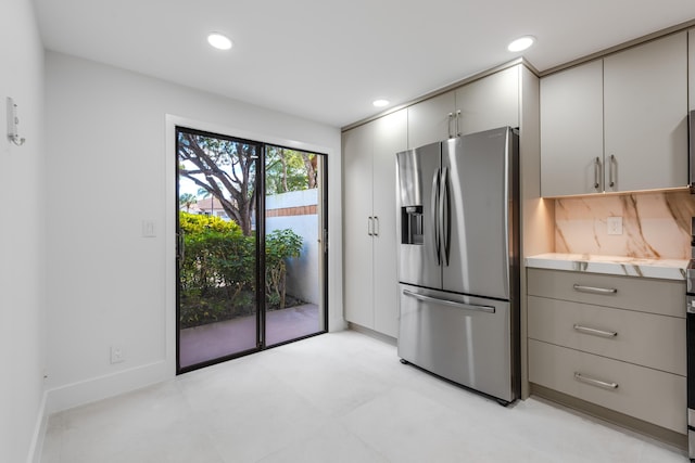 kitchen featuring backsplash, gray cabinetry, and stainless steel refrigerator with ice dispenser