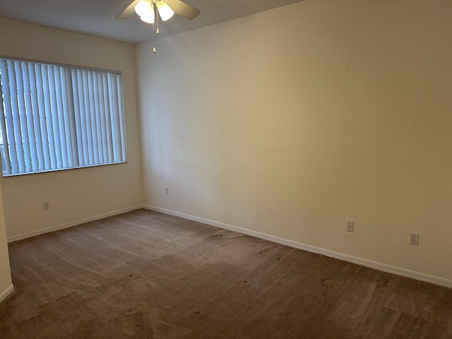 spare room with carpet floors, ceiling fan, and baseboards