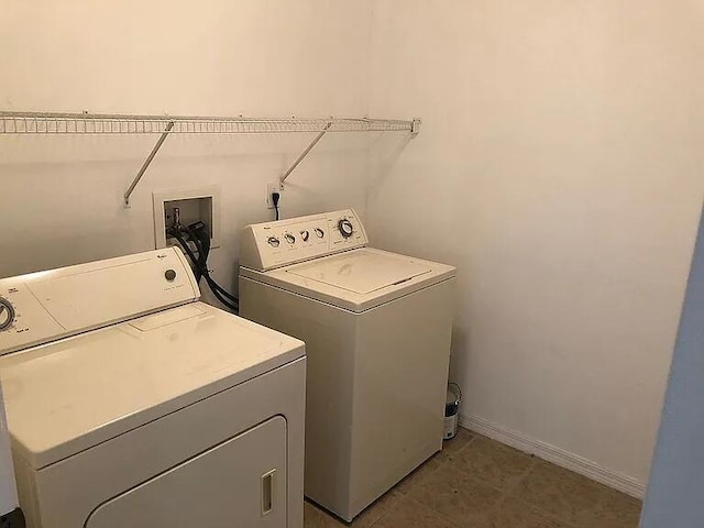 washroom with laundry area, baseboards, and washing machine and clothes dryer