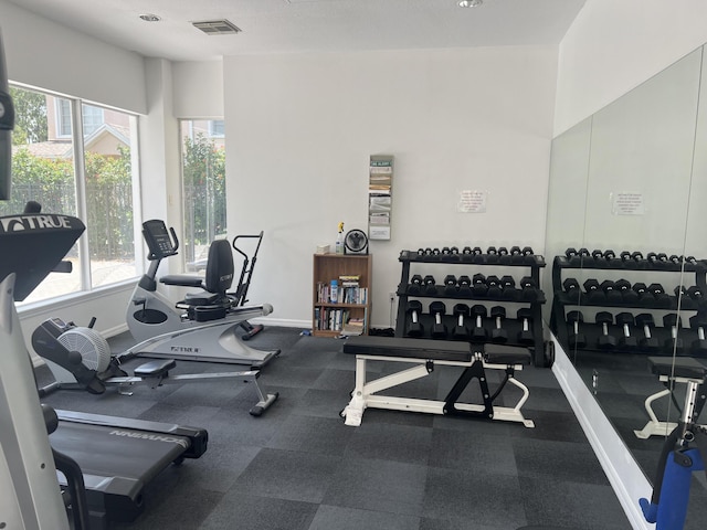 exercise room with visible vents and baseboards