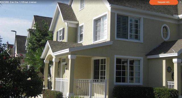 view of home's exterior with roof with shingles, fence, and stucco siding