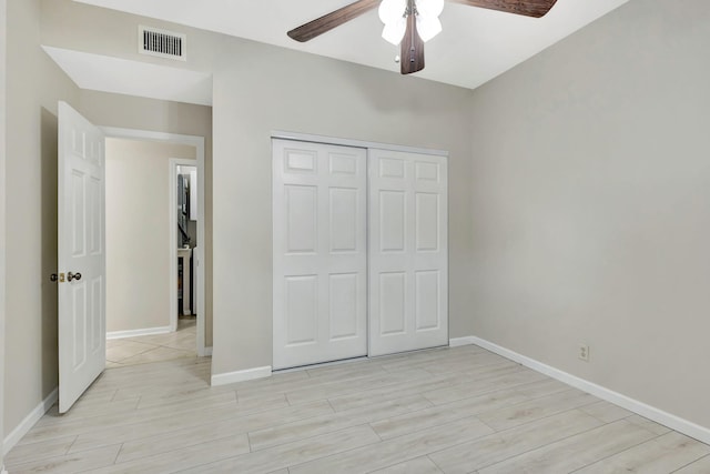 unfurnished bedroom featuring ceiling fan, light wood-type flooring, and a closet