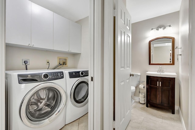 washroom with cabinets, light tile patterned floors, separate washer and dryer, and sink