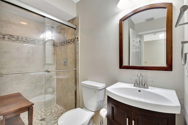 bathroom with vanity, a shower with shower door, and toilet