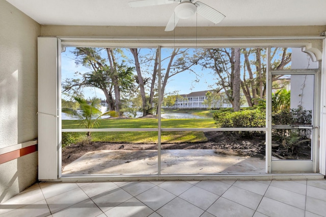 unfurnished sunroom with a water view and ceiling fan