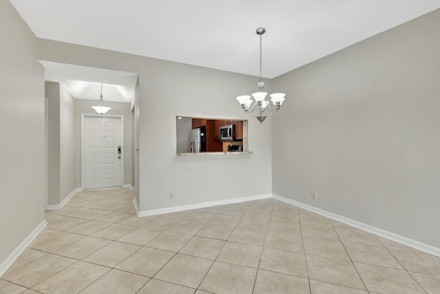 empty room featuring light tile patterned floors and a chandelier