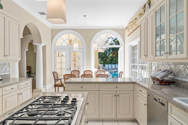 kitchen with light stone countertops, decorative backsplash, decorative columns, stainless steel appliances, and crown molding