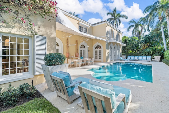 view of swimming pool featuring french doors and a patio