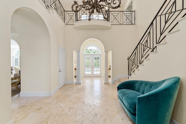 foyer featuring a chandelier, french doors, and a towering ceiling