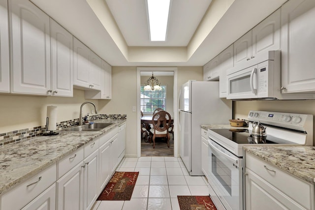 kitchen featuring white cabinetry, white appliances, sink, and an inviting chandelier