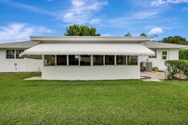 back of property featuring a lawn and central air condition unit