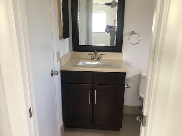 bathroom with vanity, toilet, and ceiling fan