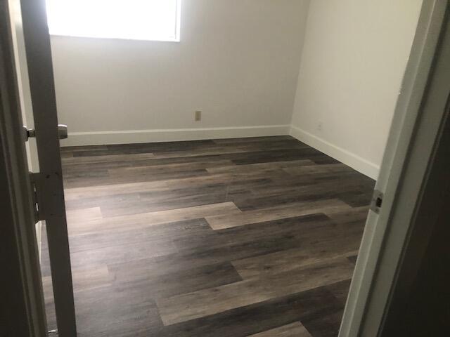 unfurnished room featuring dark hardwood / wood-style floors