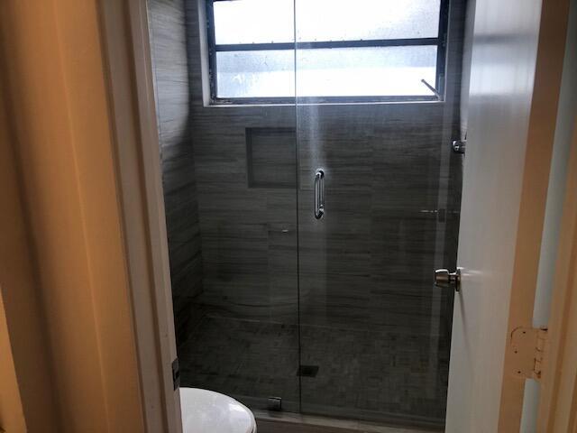 bathroom with an enclosed shower and toilet