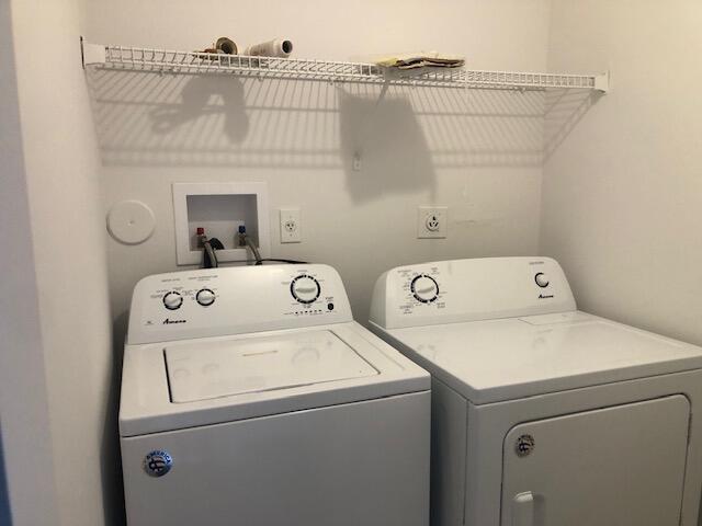 clothes washing area with washing machine and dryer