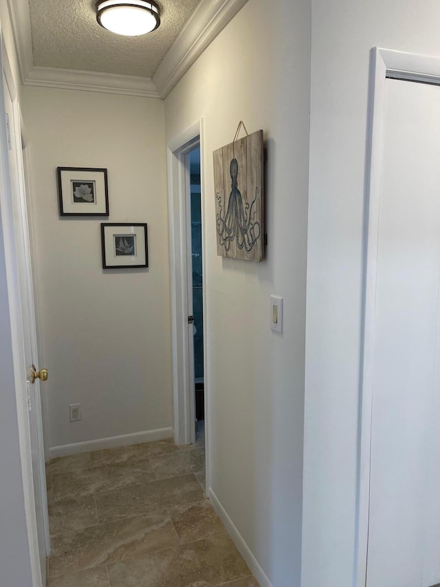 hallway featuring a textured ceiling and crown molding