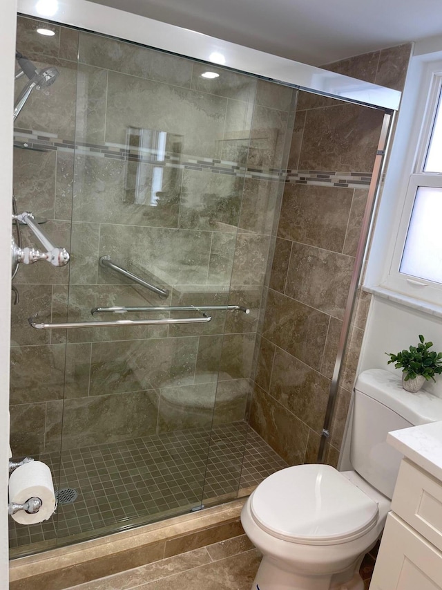 bathroom featuring an enclosed shower, vanity, toilet, and tile patterned flooring