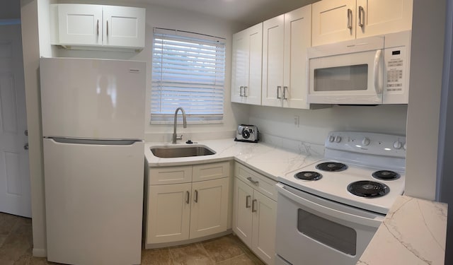 kitchen featuring white cabinetry, sink, light stone counters, and white appliances