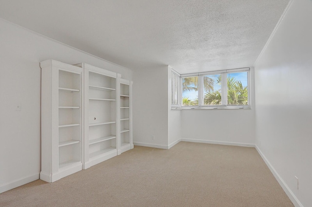 spare room with a textured ceiling and light carpet