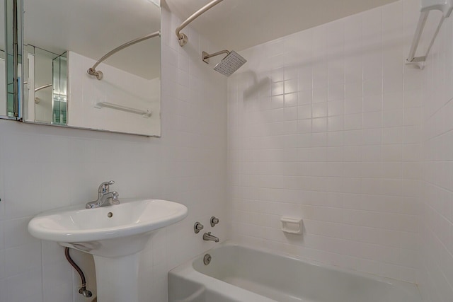 bathroom with tiled shower / bath combo and tile walls