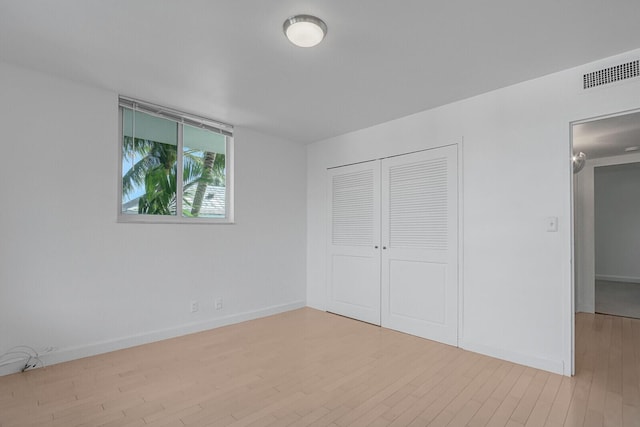 unfurnished bedroom with a closet and light hardwood / wood-style floors