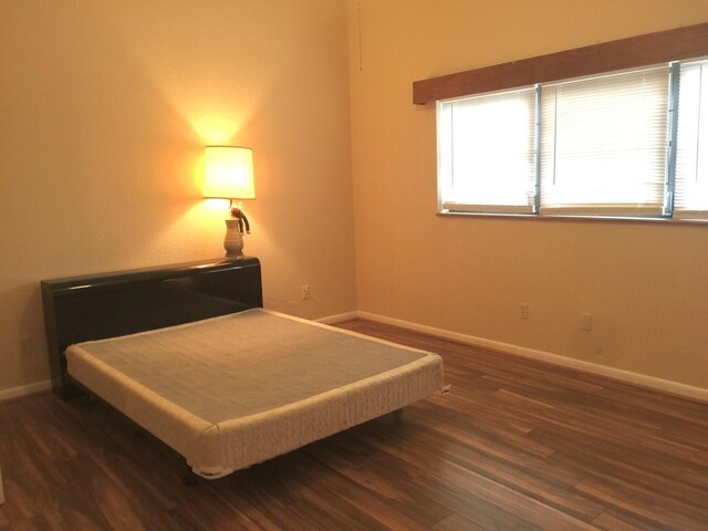 unfurnished office with dark hardwood / wood-style flooring and lofted ceiling