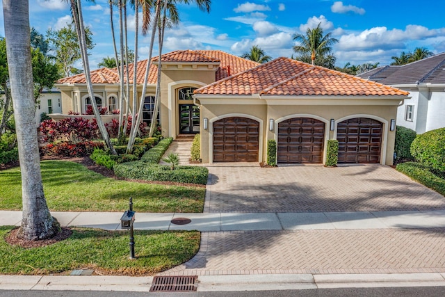 mediterranean / spanish house with a front lawn and a garage